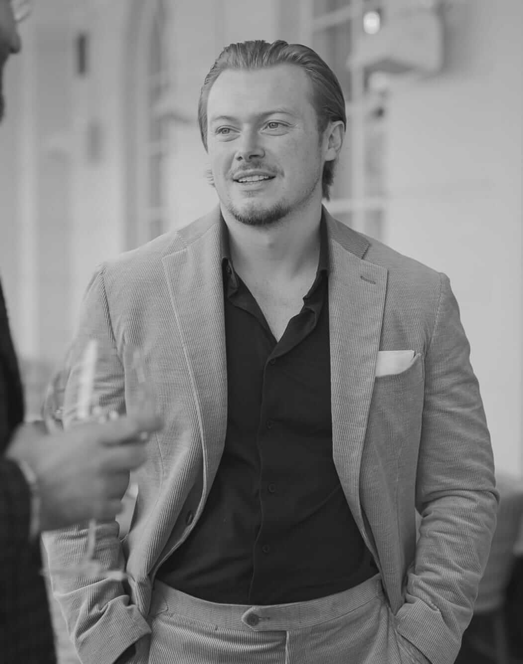 Man in light blazer holding a drink