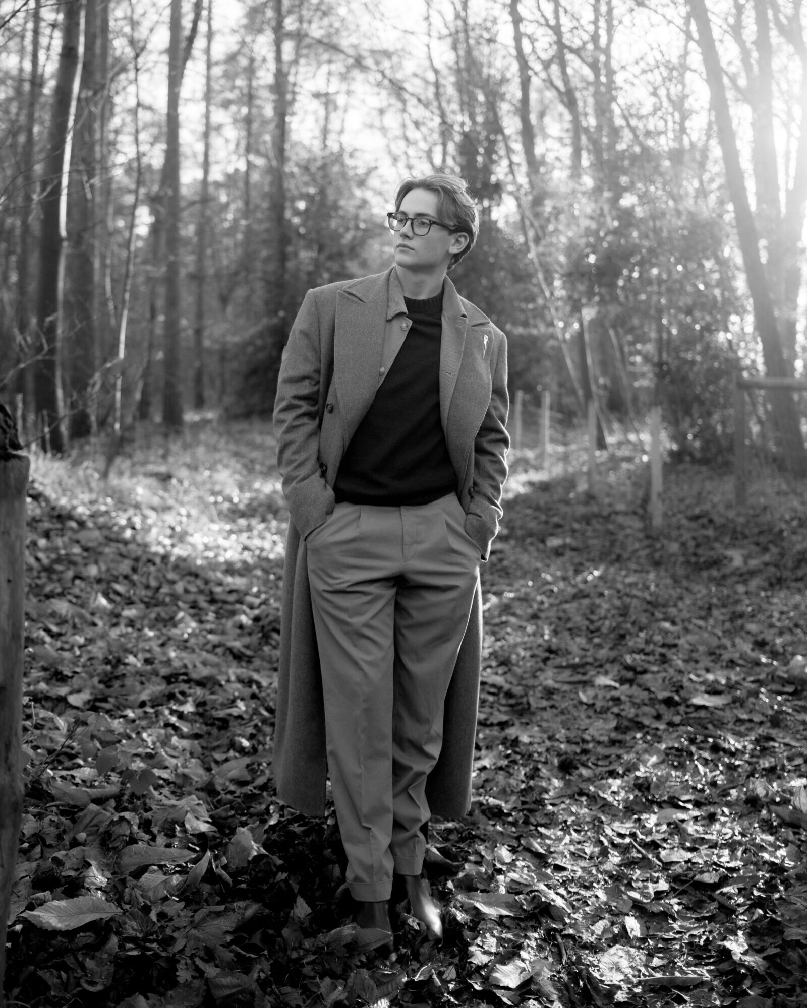 Man in tailored separates standing in a wooded clearing