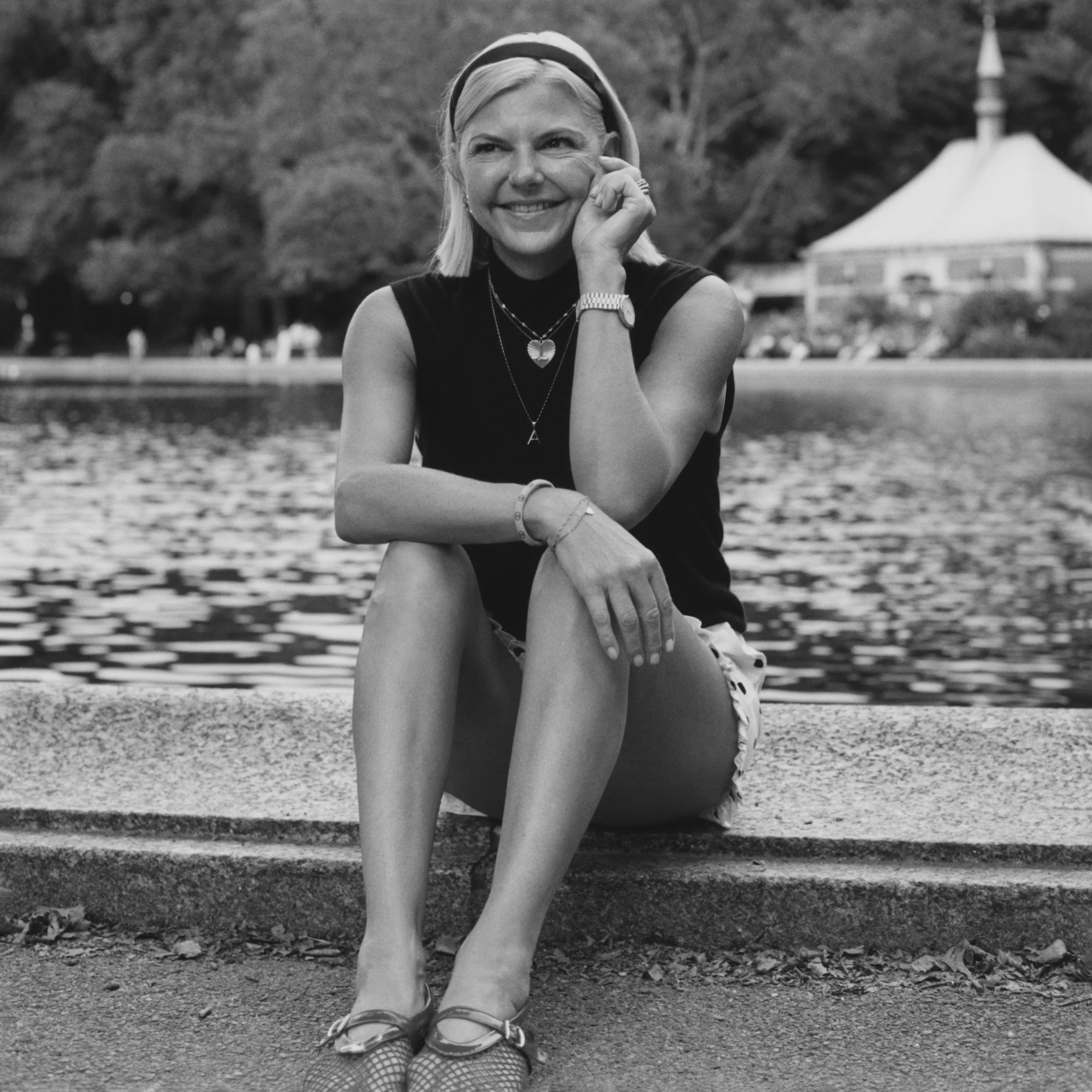 Black-and-white portrait of a seated female model wearing a tailored waistcoat, in a New York park