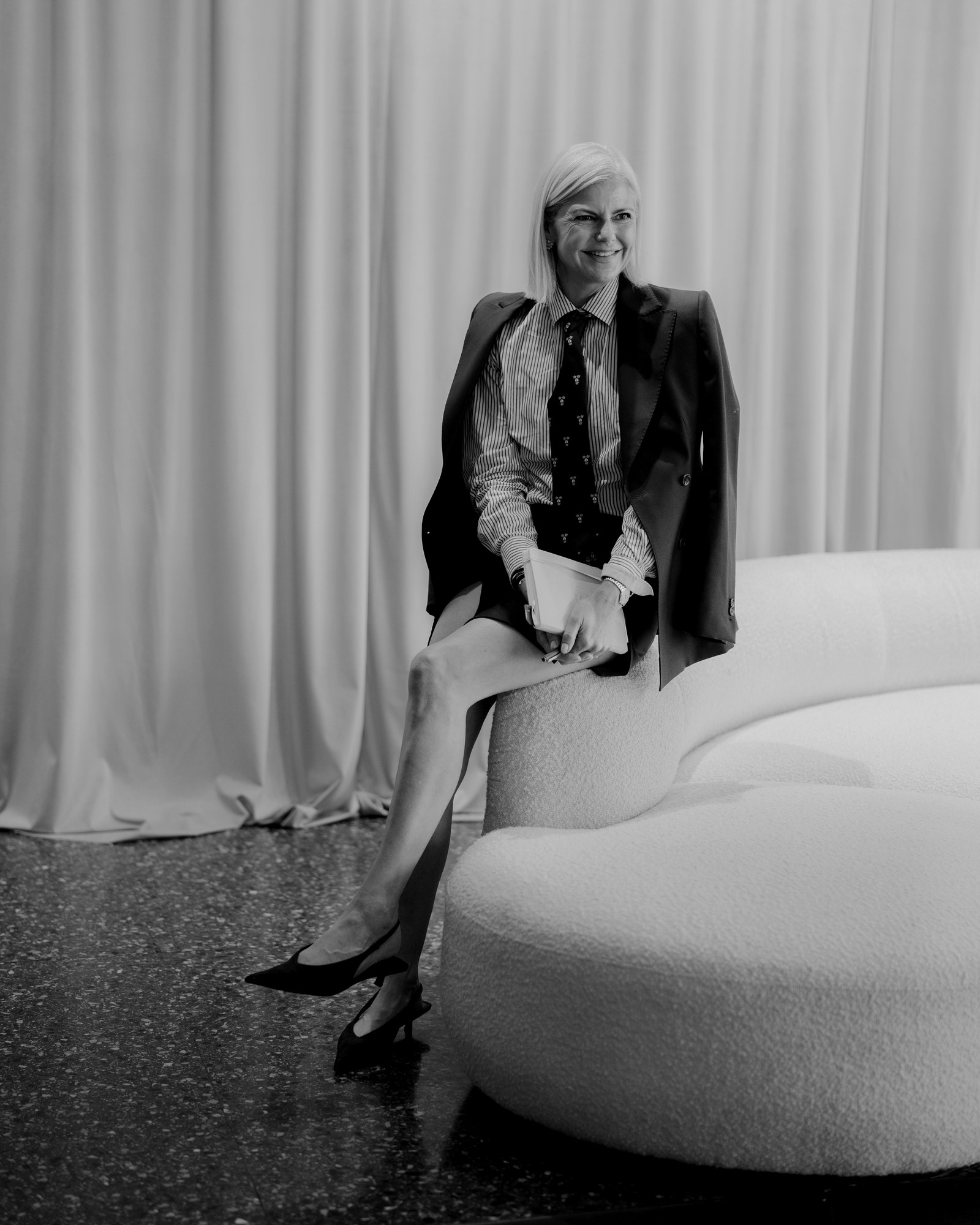 Anna Moore, Chief Creative Officer, seated in a shirt, tie and jacket