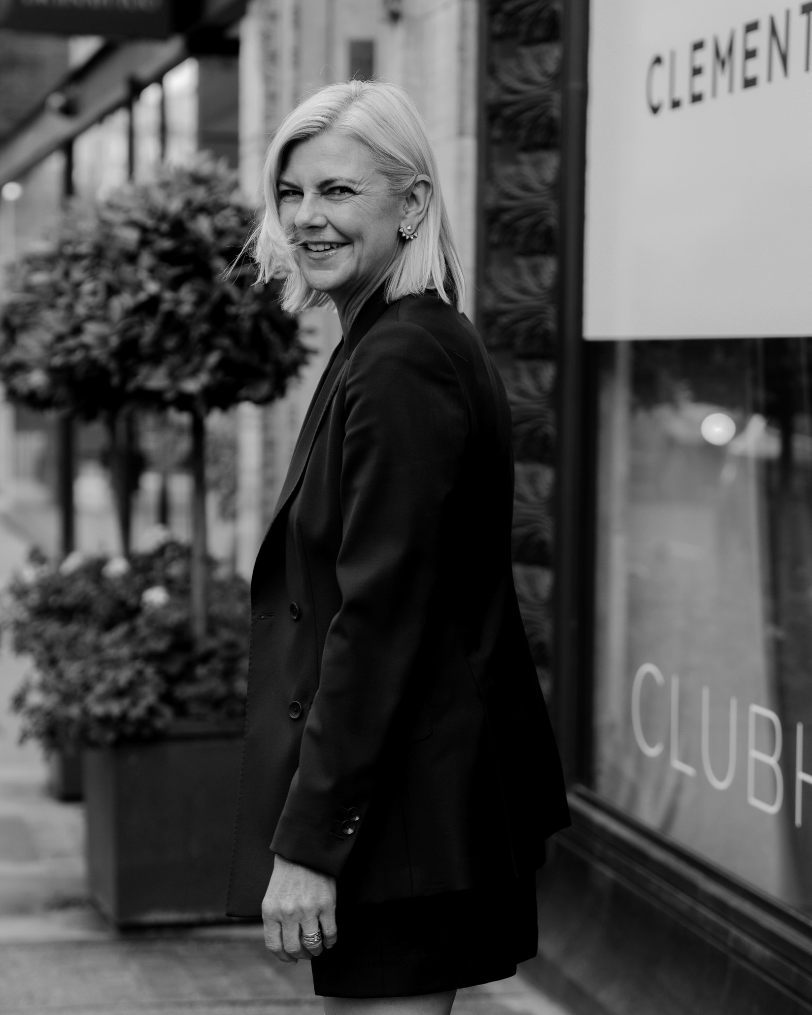 Anna Moore, Chief Creative Officer, in a double-breasted jacket and skirt outside the Clements and Church store