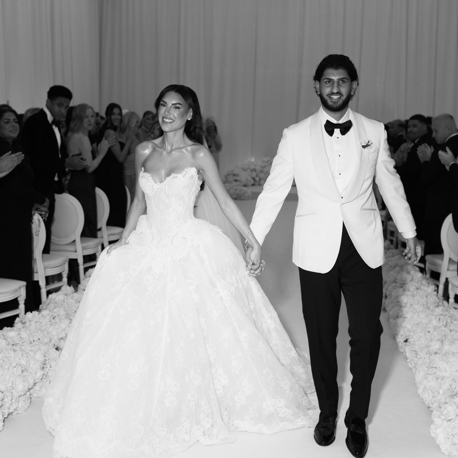 Chiara and Joey walking hand in hand down the aisle