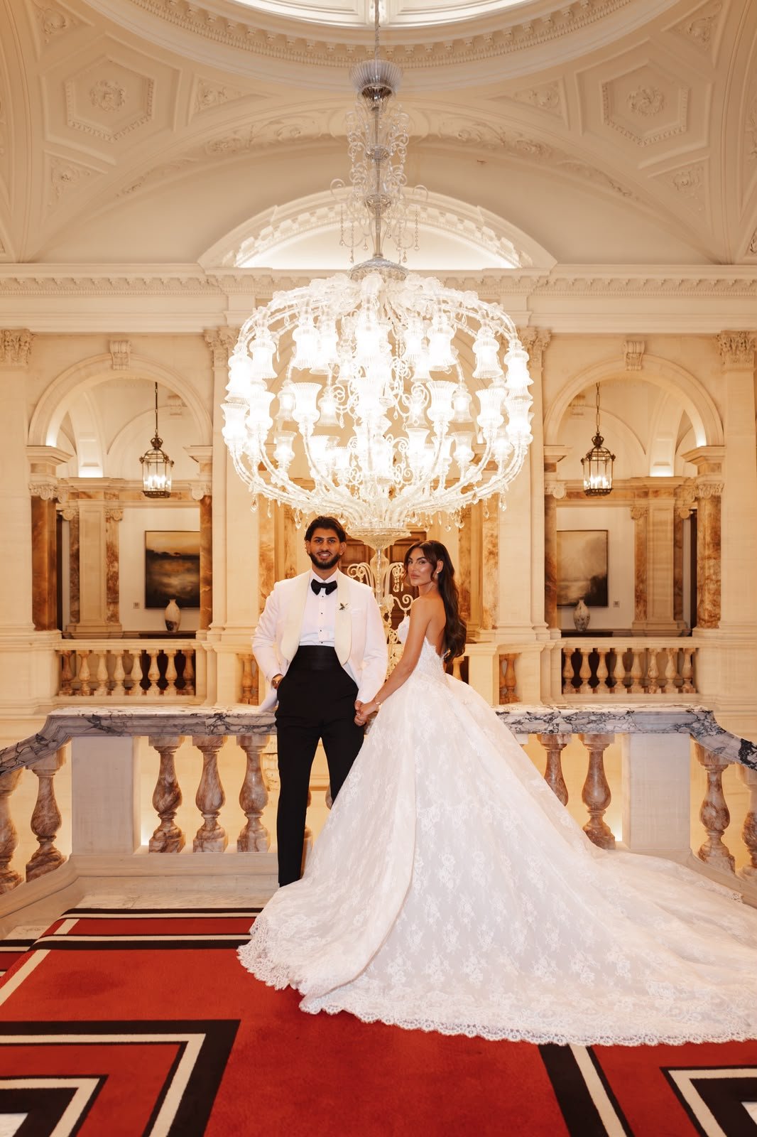 Chiara and Joey beneath a crystal chandelier at Raffles London at The OWO