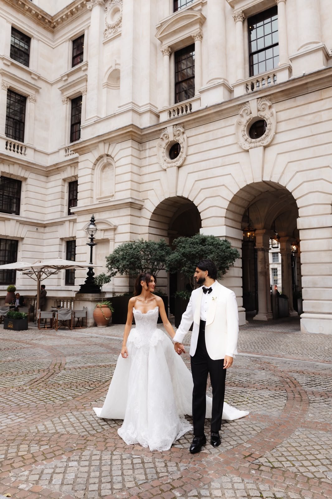 Chiara and Joey in the courtyard of Raffles London at The OWO, Joey in an ivory dinner jacket