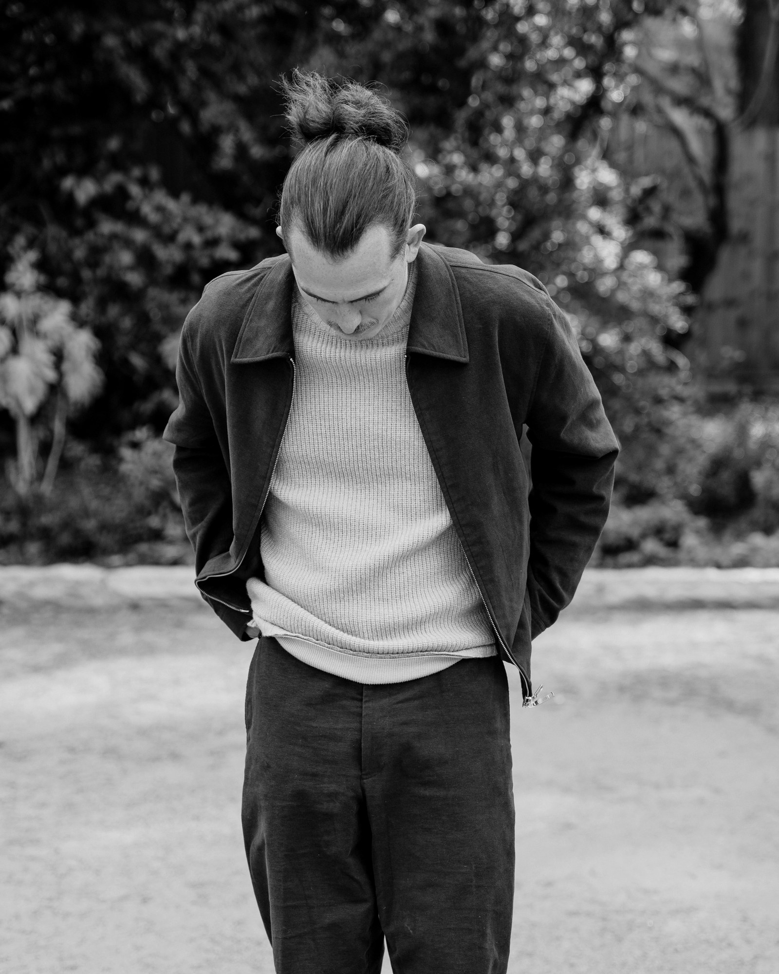 Freddie Grant, Beaconsfield Tailor, in a dark jacket and knitted jumper in a garden