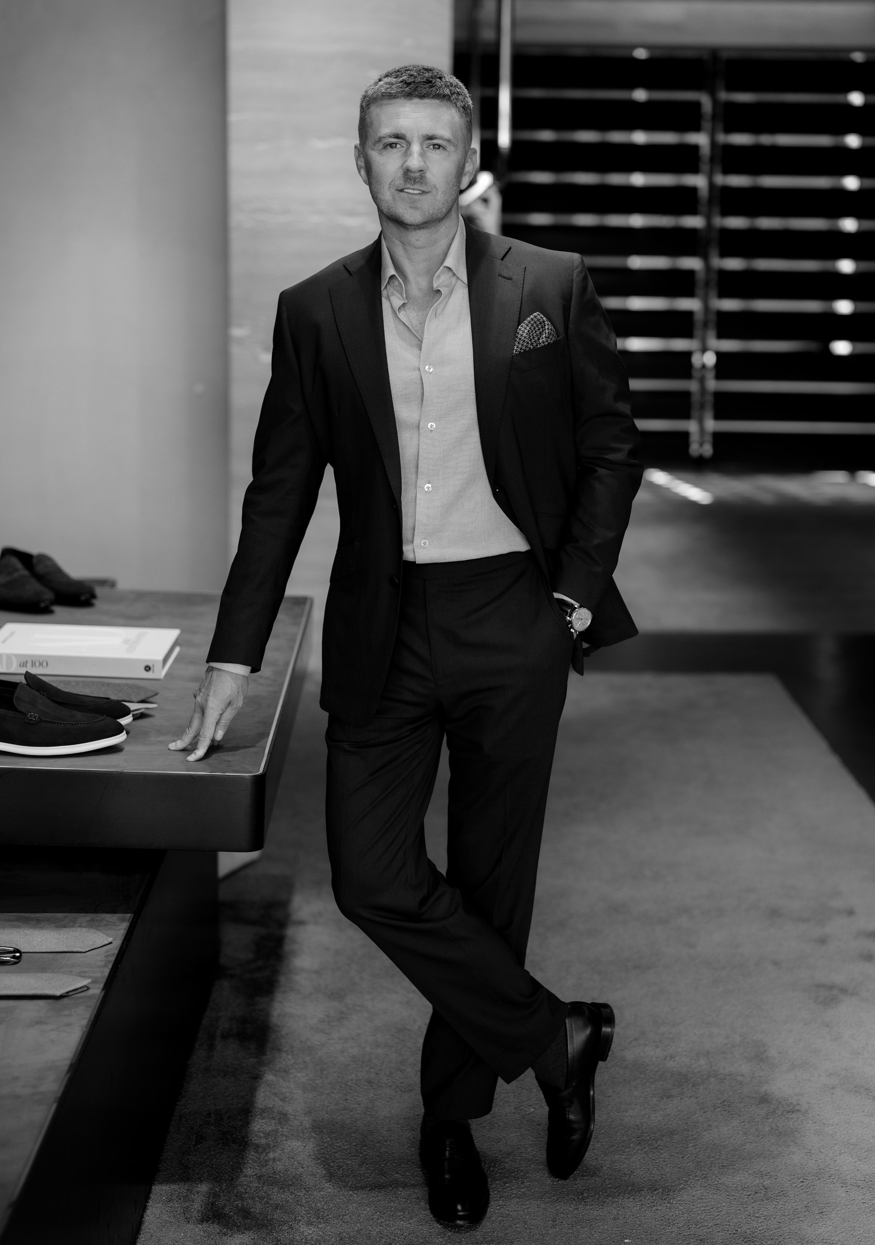 Jake Thompson, Oxford Head Tailor, in a dark suit leaning against a display table