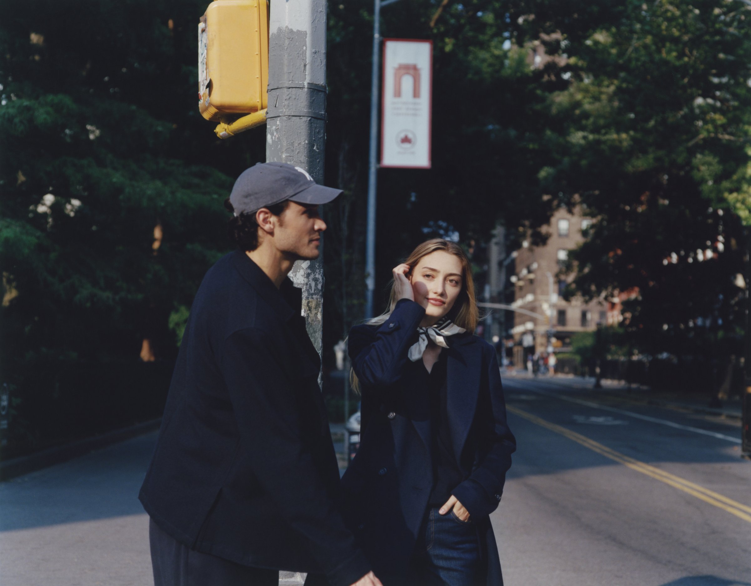 Man in a cap and navy jacket beside a woman in a navy coat and silk neckerchief on a New York street