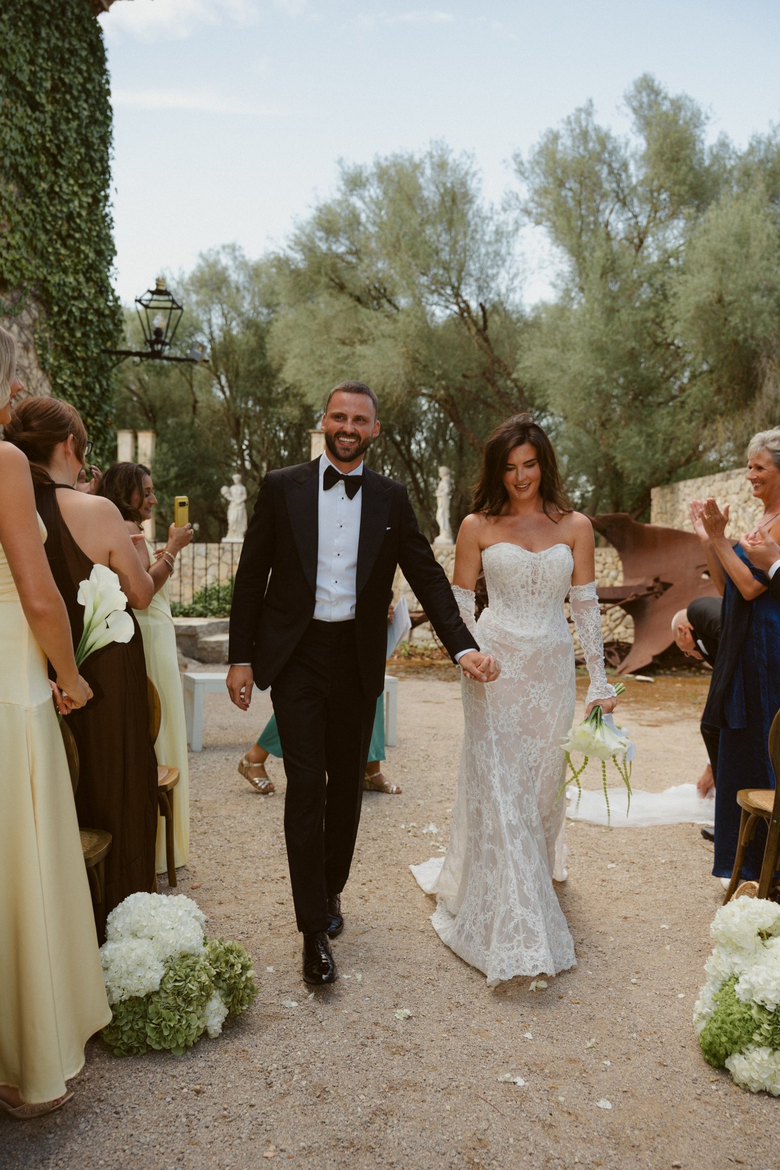 Rebekah and Brad walking back down the aisle as guests look on